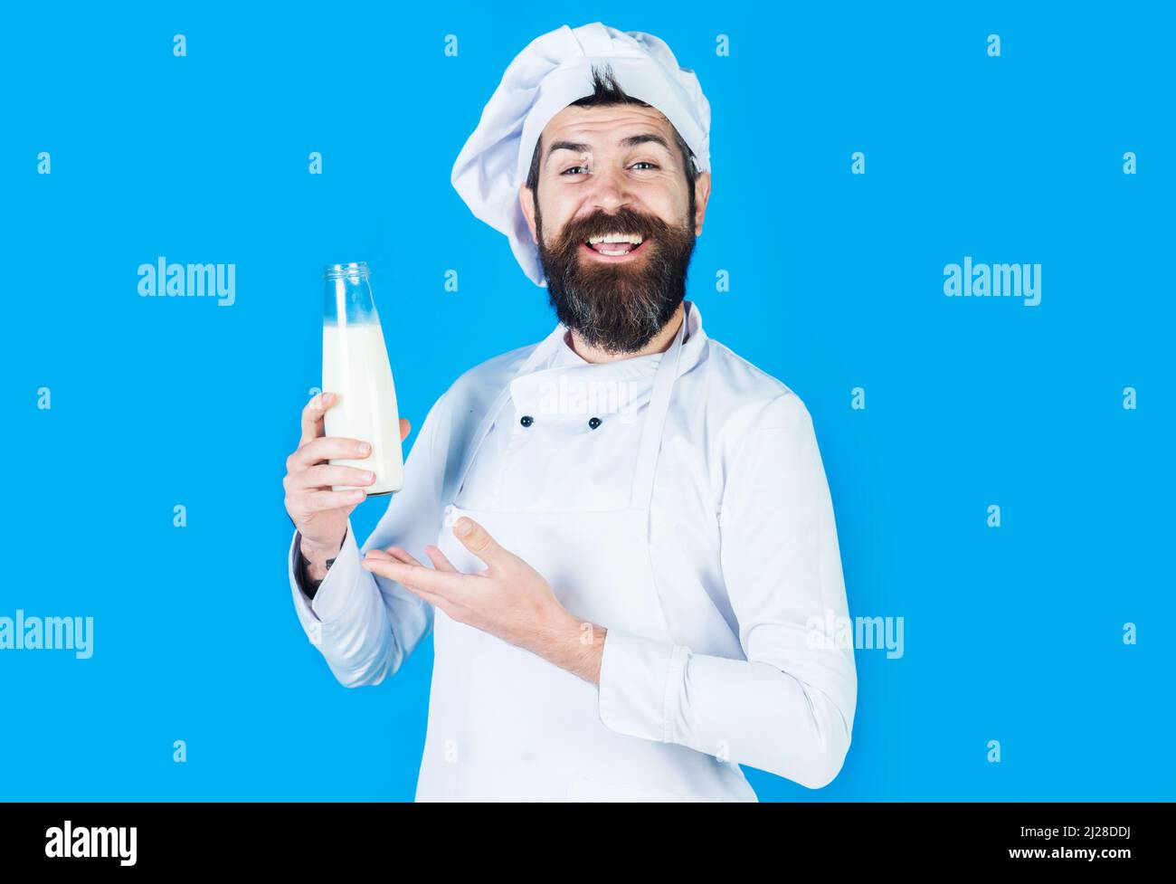 Chef barbu présentant du lait en bouteille ou du milkshake. Produits laitiers. Régime protéinique. Yaourt sans lactose. Banque D'Images