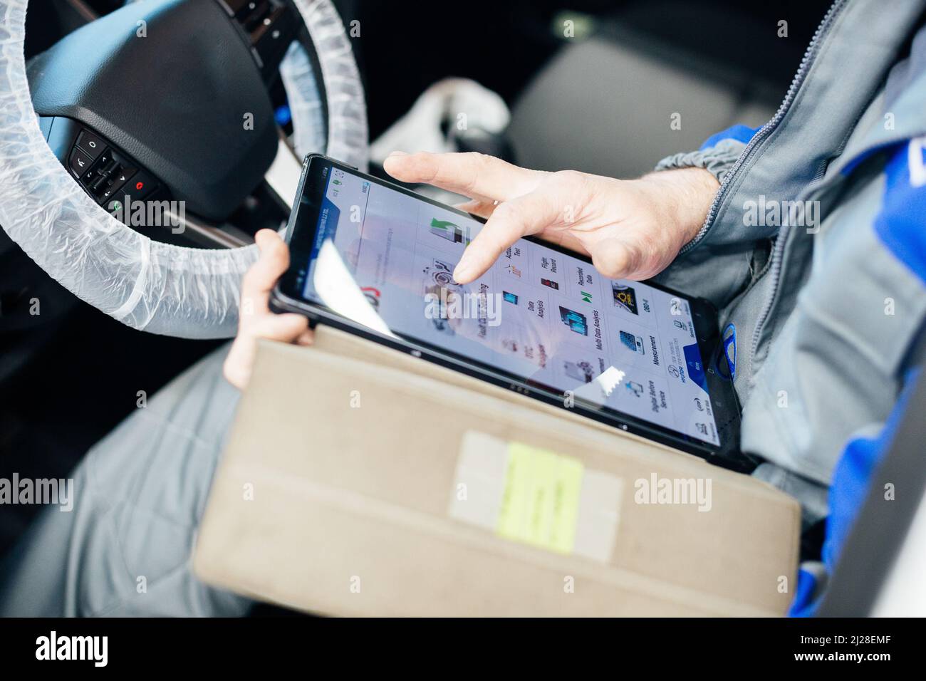 Un ingénieur de sexe masculin effectue un diagnostic informatique de la voiture en service automatique. Banque D'Images Un ingénieur de sexe masculin effectue un diagnostic informatique de la voiture en service automatique. Banque D'Images