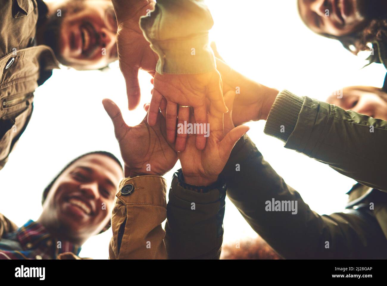 Faire un pacte pour rester amis pour toujours. Prise de vue en contre-angle d'un groupe d'amis qui se mettent à empiler les mains tout en restant debout à l'extérieur. Banque D'Images