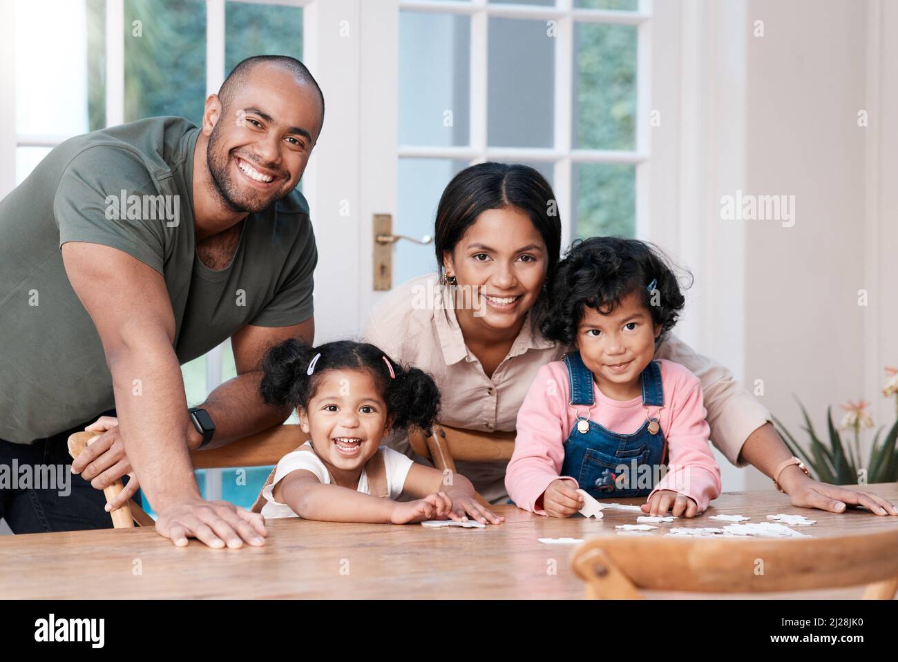 C'est éducatif et amusant pour toute la famille. Portrait d'une famille heureuse construisant un puzzle à la maison. Banque D'Images