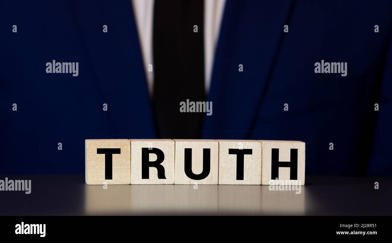 Vérité - mot à partir de blocs de bois avec des lettres, réalité concept de vérité, lettres aléatoires autour, fond blanc. Banque D'Images