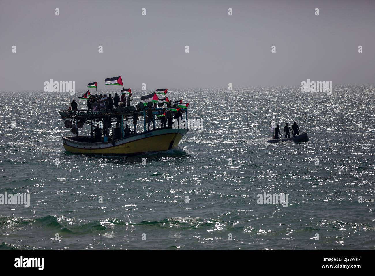 Gaza, Palestine. 30th mars 2022. Les pêcheurs palestiniens ravirent leurs bateaux tout en agitant leurs drapeaux nationaux lors d'un rassemblement marquant le 46th anniversaire dans l'eau de la mer Méditerranée au port des pêcheurs de la ville de Gaza. 46th anniversaire de la Journée des terres, qui marque un incident qui a eu lieu en 1976, lorsque les troupes israéliennes ont abattu six personnes lors de manifestations contre les confiscations de terres. (Photo de Mahmoud Issa/SOPA Images/Sipa USA) crédit: SIPA USA/Alay Live News Banque D'Images