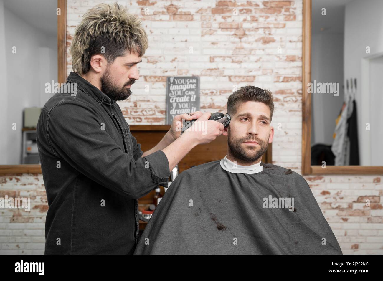 Homme barber coupe les cheveux de client masculin avec la tondeuse au salon  de coiffure. Processus de coiffage. Photographie de haute qualité Photo  Stock - Alamy