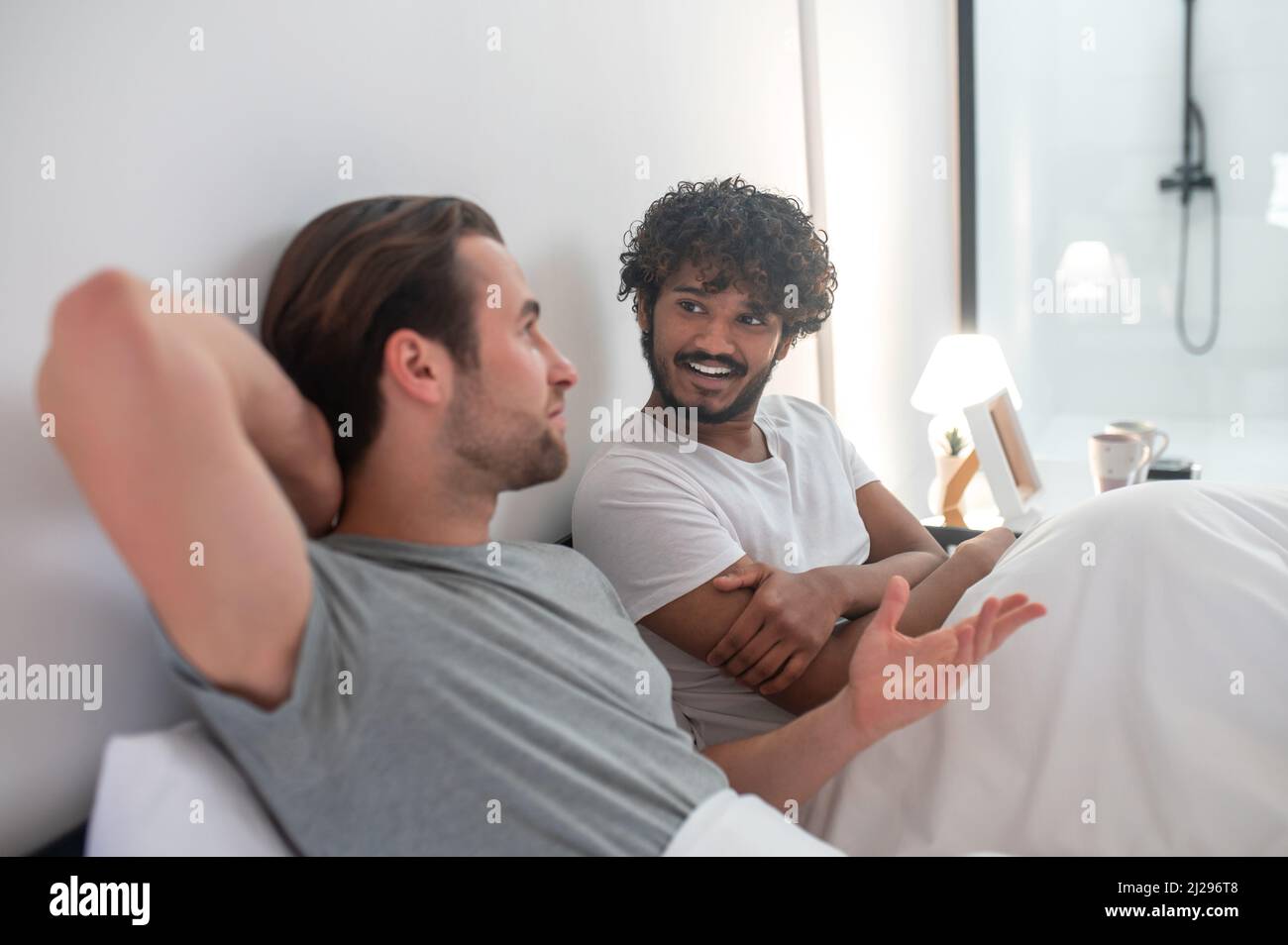 Joyeux homme regardant son petit ami pendant leur conversation intime Banque D'Images