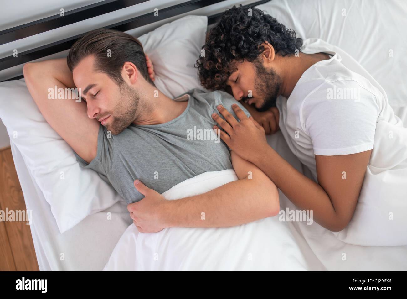 Un couple de hommes dormant paisiblement dans leur chambre Banque D'Images