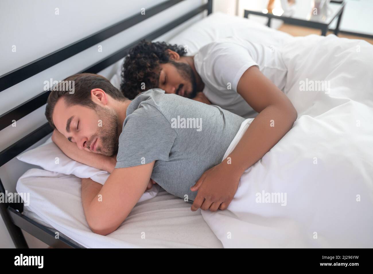 Couple gay romantique se délassant dans leur chambre Banque D'Images