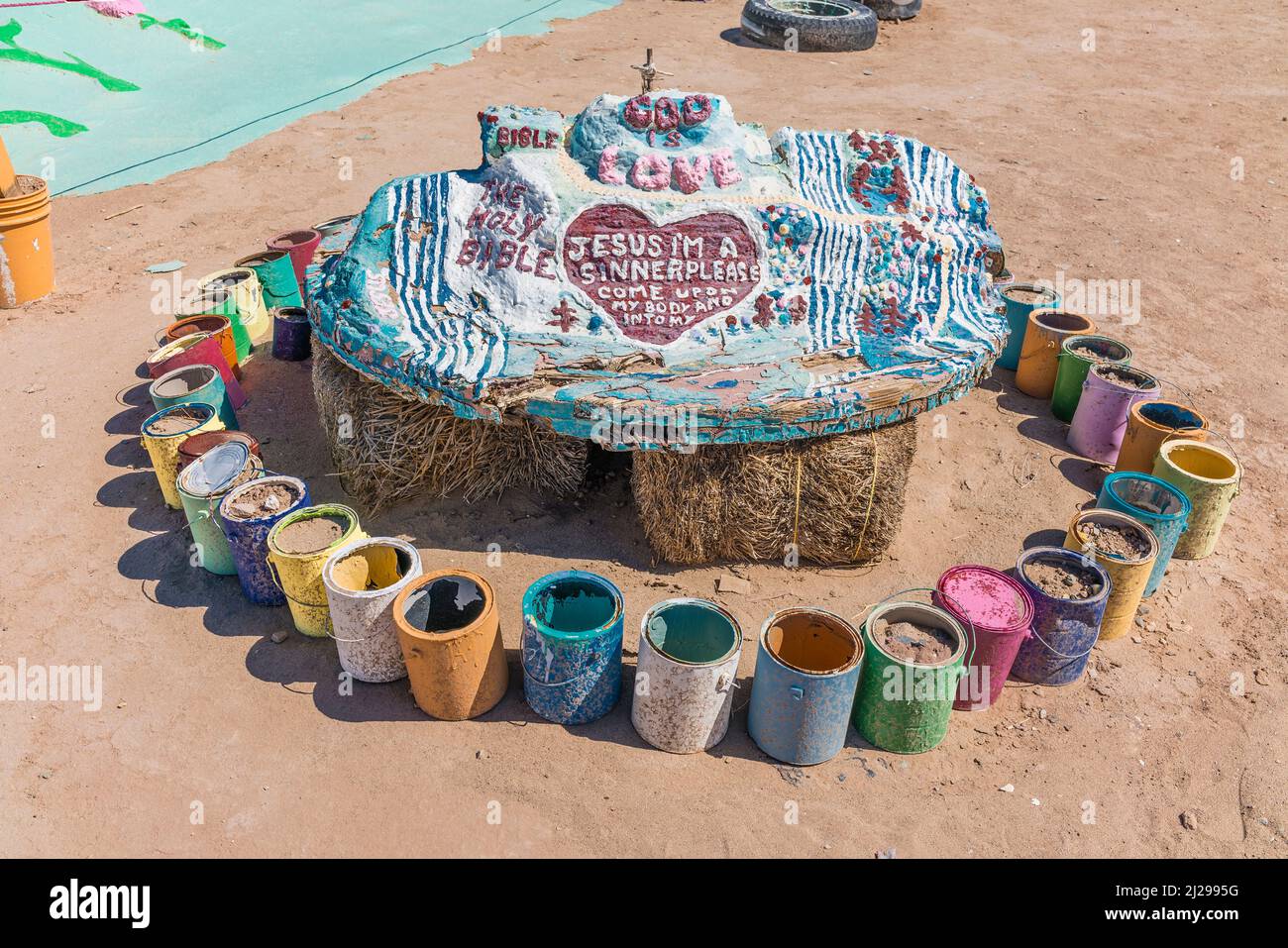 Modèle à échelle du mont du Salut assis sur des balles de foin au sol entouré de boîtes de peinture de différentes couleurs. Banque D'Images