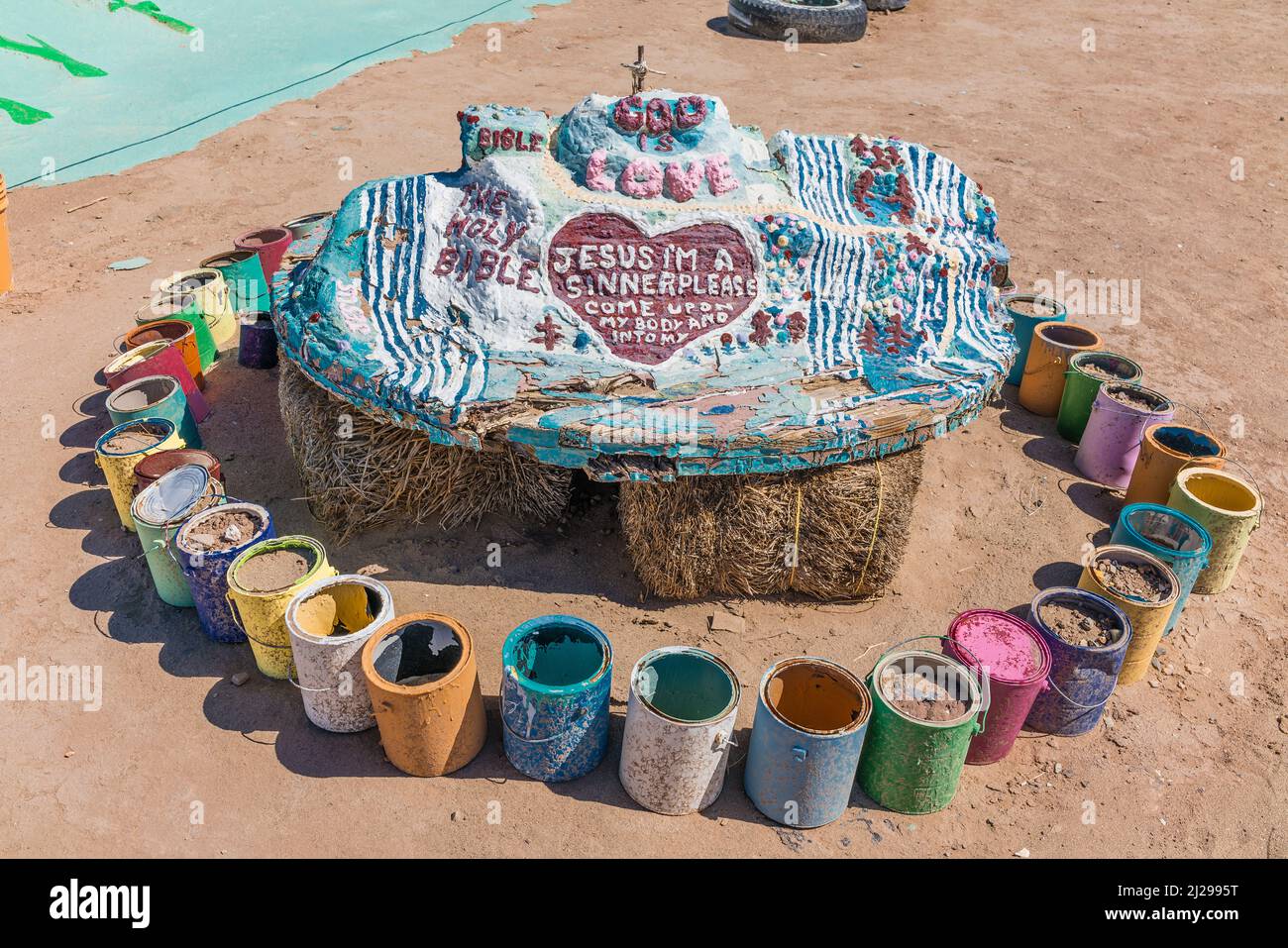 Modèle à échelle du mont du Salut assis sur des balles de foin au sol entouré de boîtes de peinture de différentes couleurs. Banque D'Images