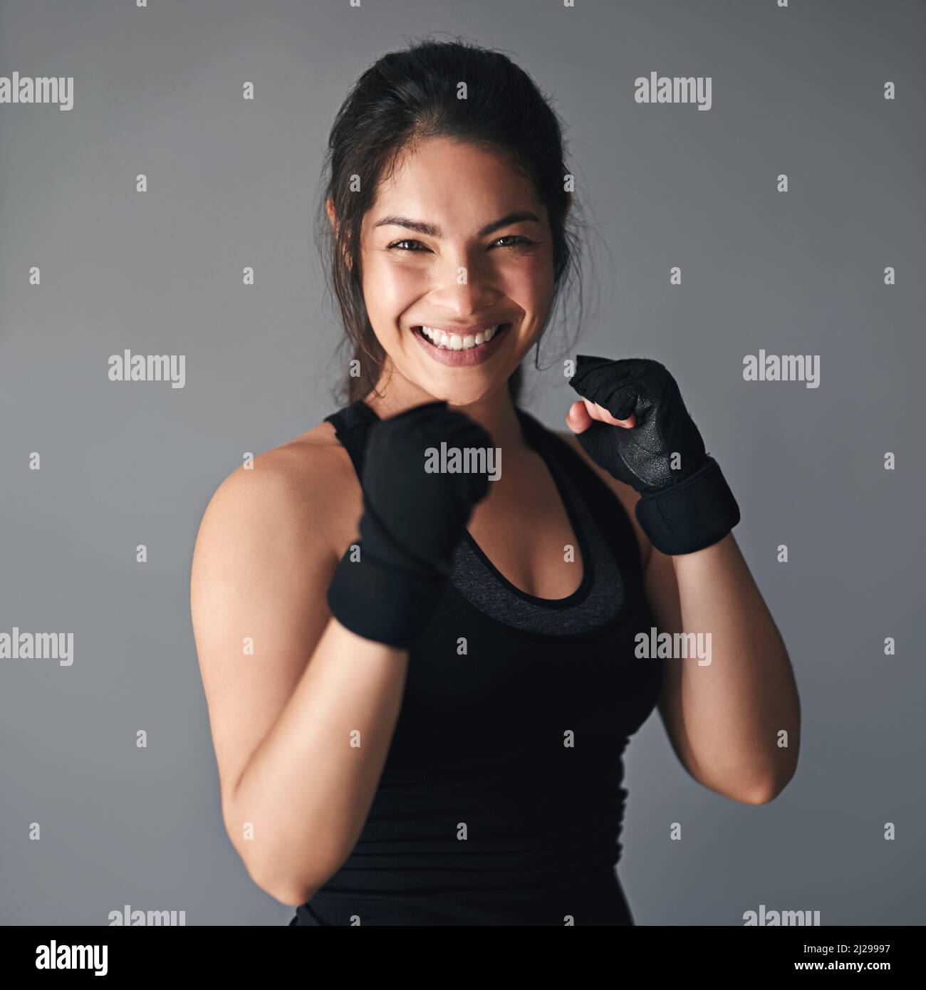 Ses a eu beaucoup de combat en elle. Photo en studio d'un kickboxer féminin sur fond gris. Banque D'Images