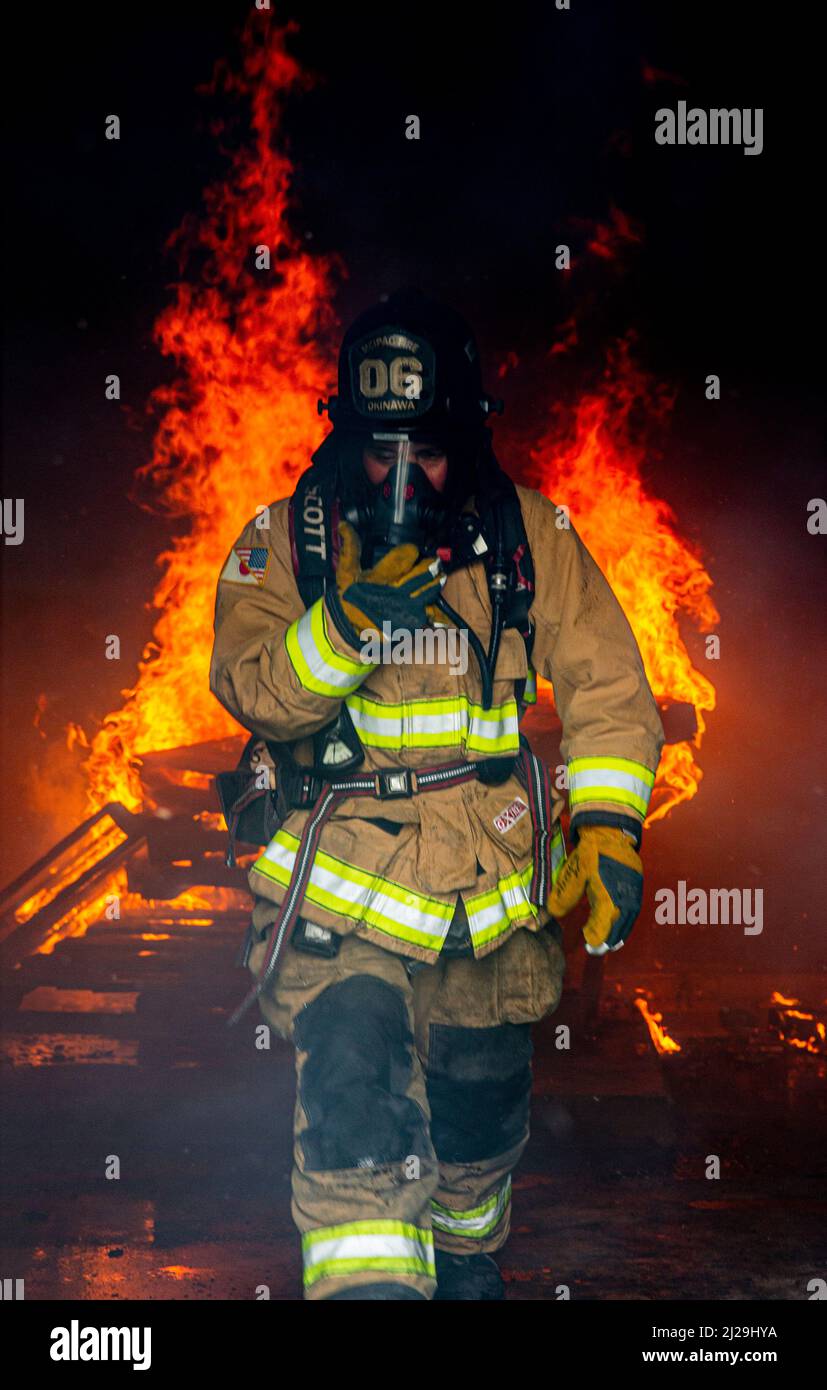 Un pompier avec des installations de corps de Marines Pacific Fire and Emergency Services quitte une salle de combustion lors d'un exercice bilatéral d'entraînement en direct sur le feu à Camp Hansen, Okinawa, Japon, le 25 mars 2022. Le CMCIPAC F&ES et le service des incendies de la ville de Naha ont rassemblé et organisé une formation en direct sur les incendies afin de comparer les différentes techniques et méthodes de lutte contre les incendies utilisées par chaque service pour accomplir la même mission. (É.-U. Photo du corps marin par Cpl. Alex Fairchild) Banque D'Images