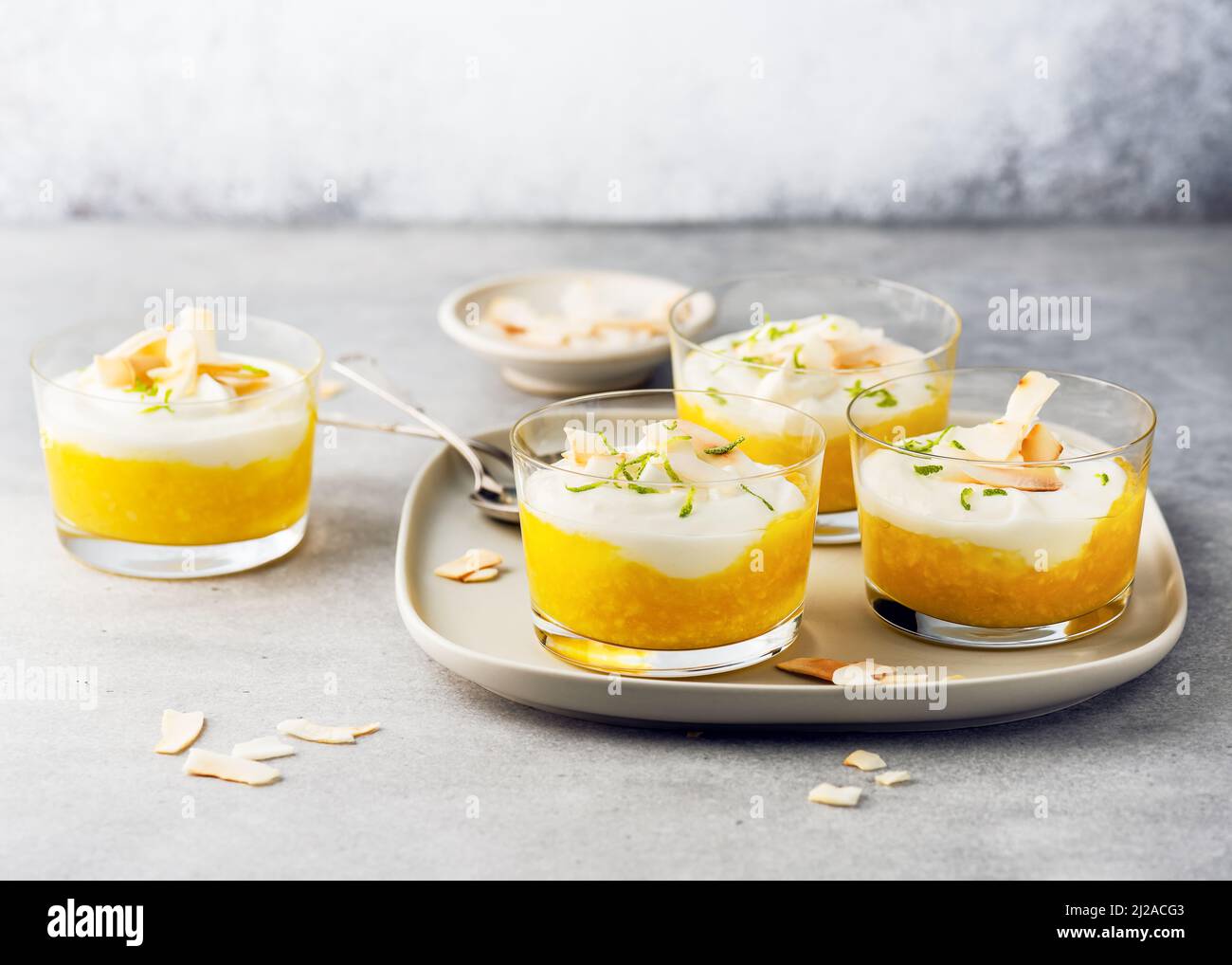 Dessert végétarien à la crème de fruits avec lait de coco et purée de mangue en pots de verre. Banque D'Images