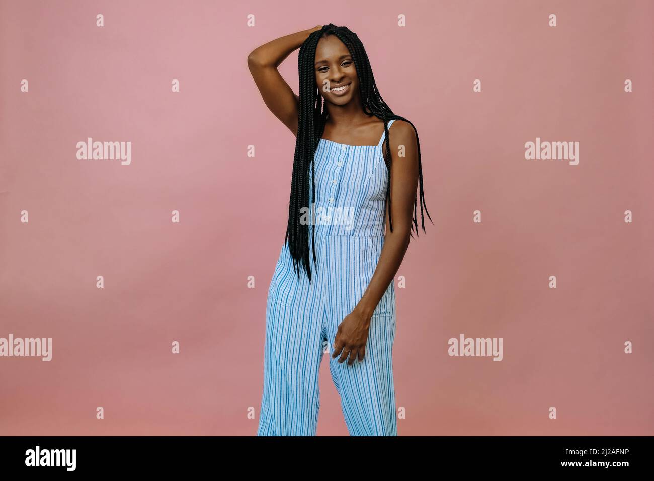 photo d'une femme noire en combinaison posant en studio sur un portrait d'arrière-plan rose et bleu Banque D'Images
