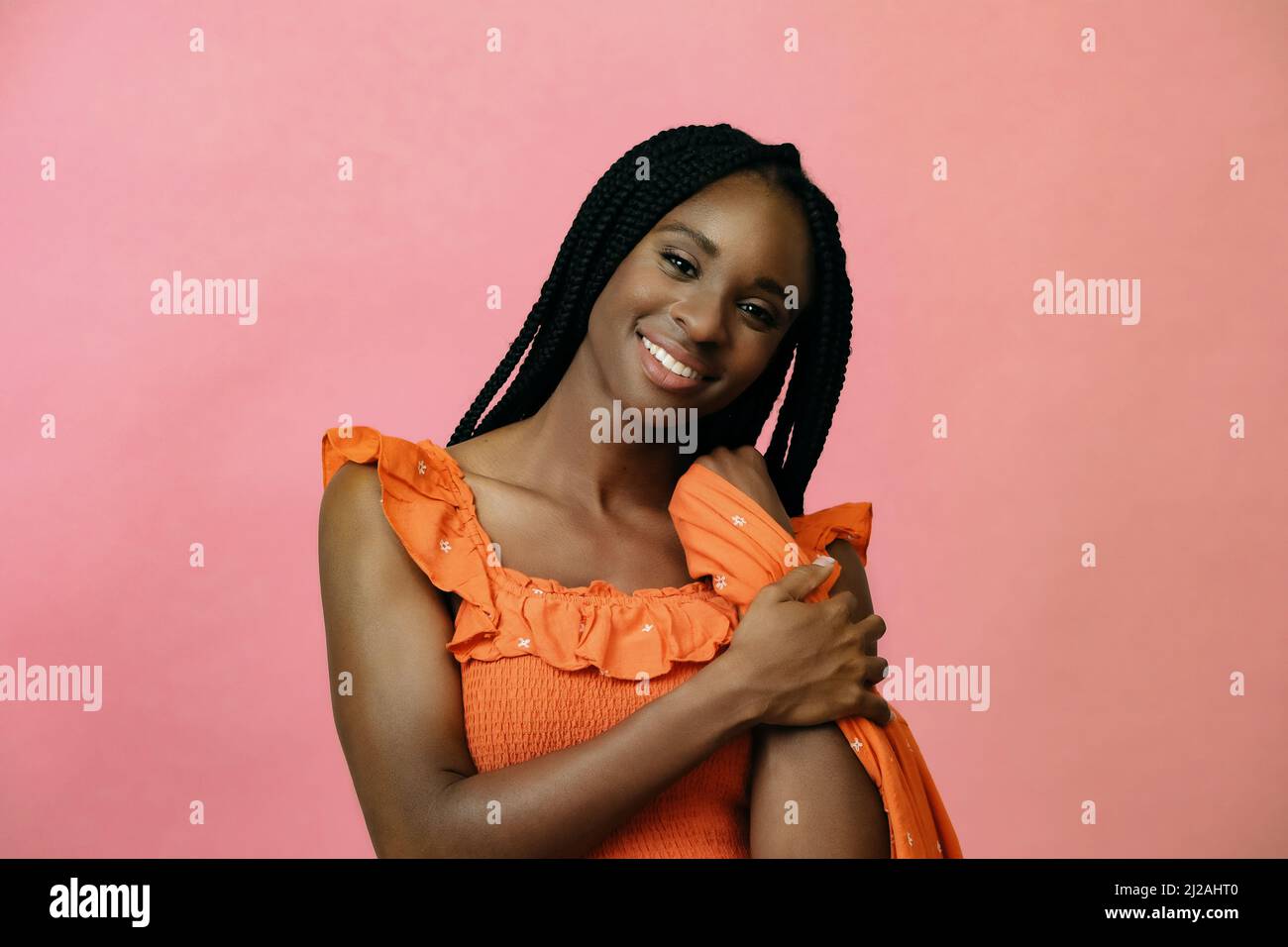 portrait de la femme noire heureuse regardant l'appareil photo et souriant avec le tissu robe dans les mains portrait Banque D'Images