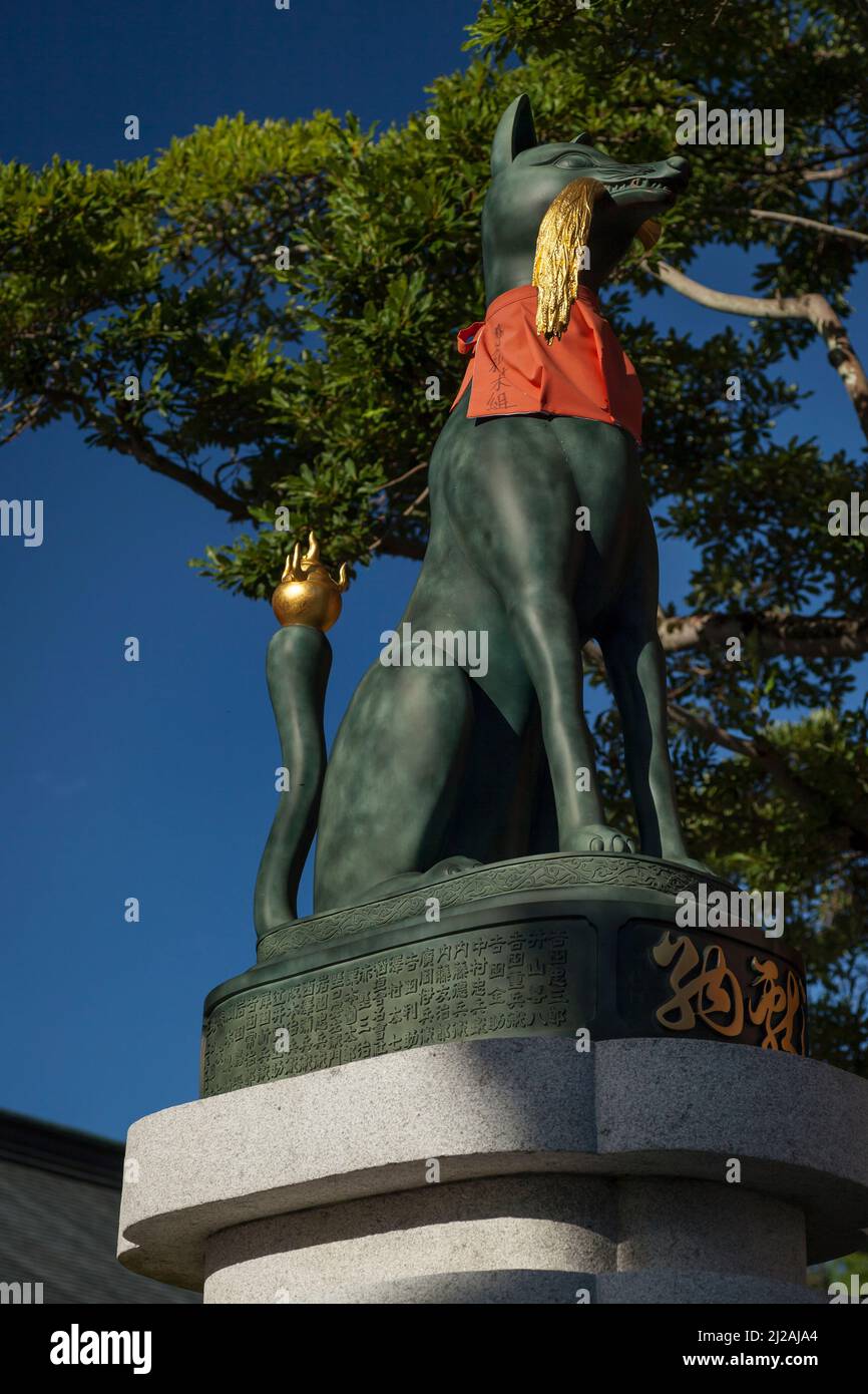 Vue verticale d'une statue verte de Kitsune (renard sur garde) dans le Shinto Fushimi-Inari Taisha Shinto Shrine, Kyoto, Japon Banque D'Images