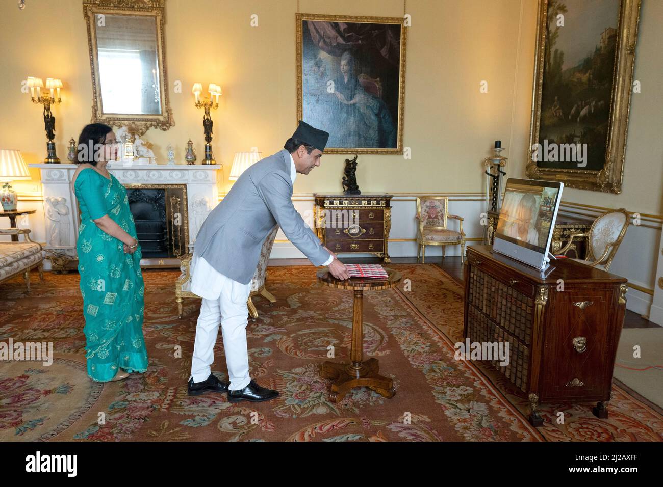 La reine Elizabeth II, en résidence au château de Windsor, apparaît sur un écran par videolink, lors d'une audience virtuelle pour recevoir l'ambassadeur de la République fédérale démocratique du Népal son Excellence M. Gyan Chandra Acharya et Mme Acharya à Buckingham Palace, Londres. Date de la photo: Jeudi 31 mars 2022. Banque D'Images