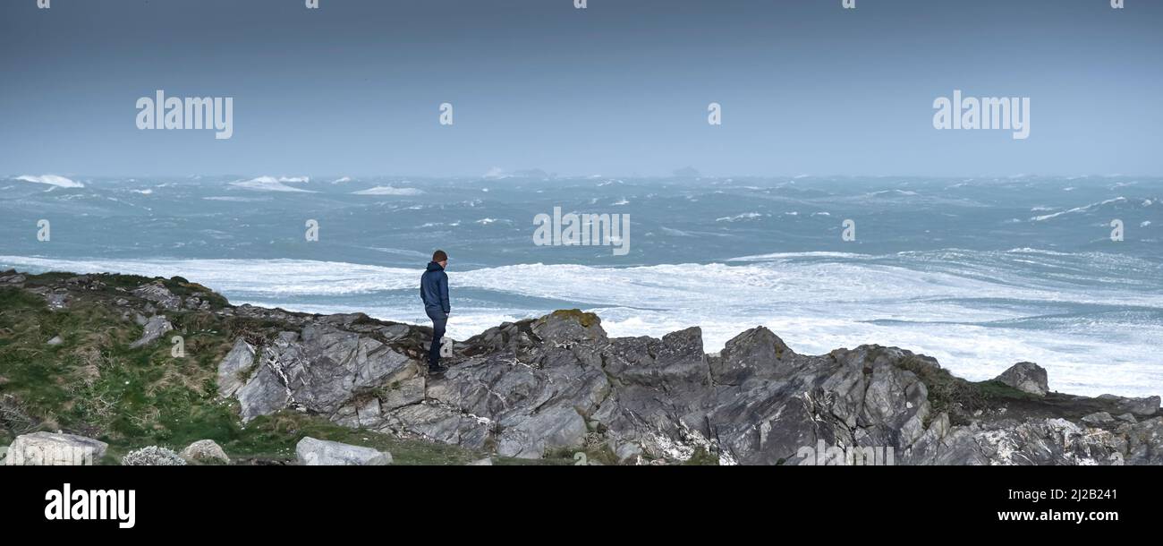 Image panoramique d'une personne debout sur Towan Head et regardant le temps sauvage causé par Storm Eunice lorsqu'il arrive sur la côte nord de Cornwall dans le Banque D'Images