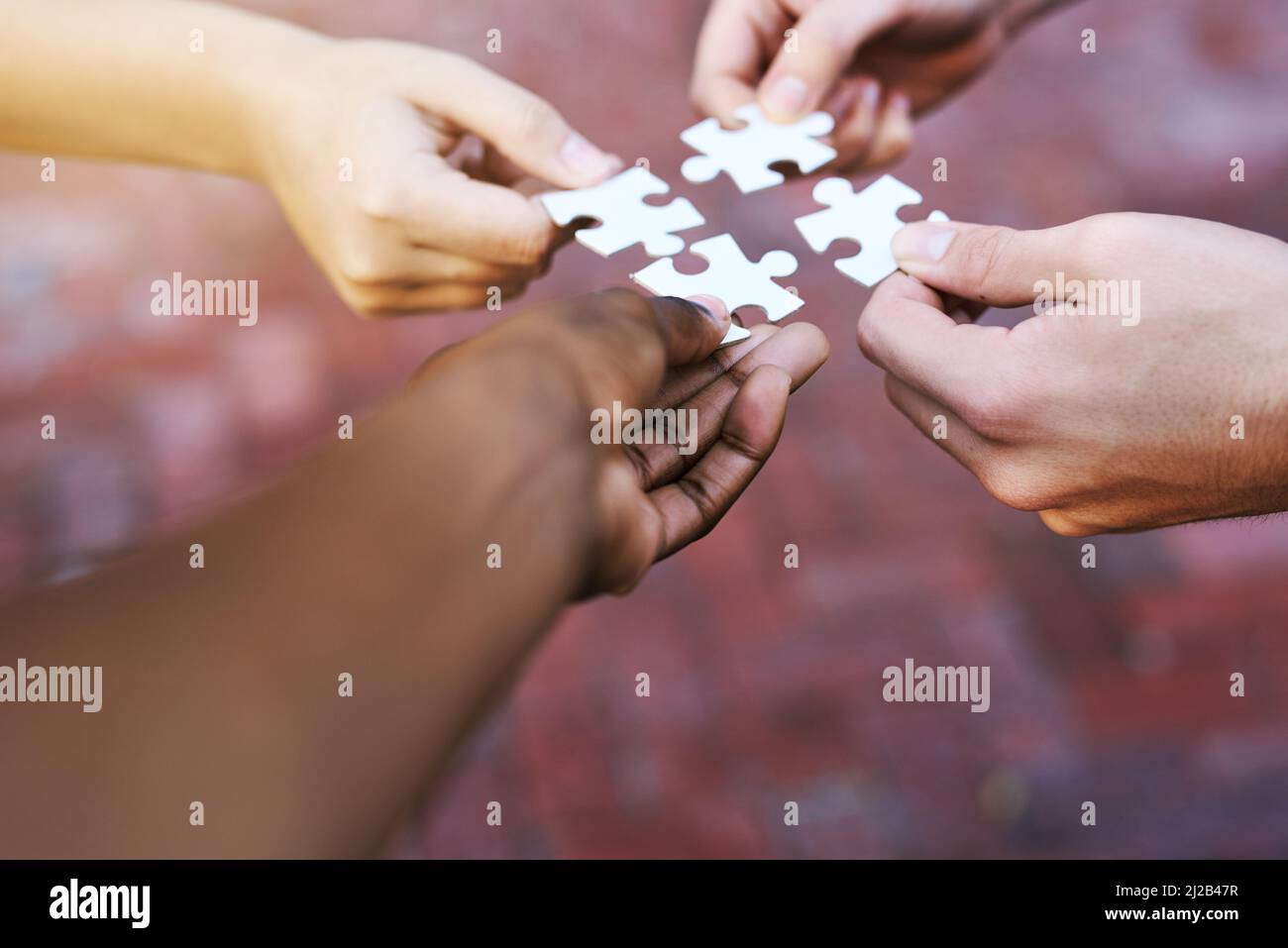 Trouver des solutions morceau par morceau. Photo de mains mettant des pièces de puzzle ensemble. Banque D'Images