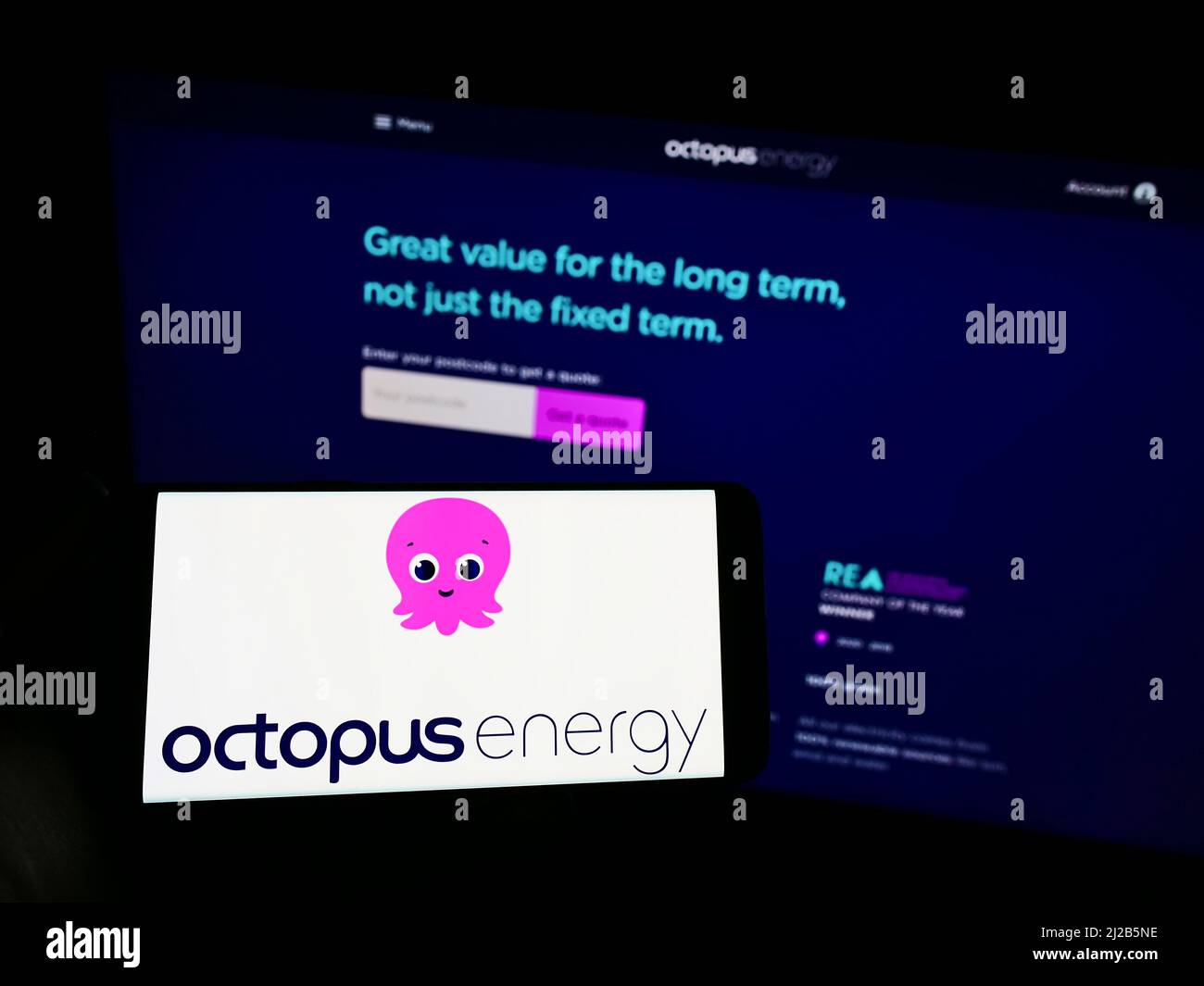 Personne tenant un smartphone avec le logo de la société britannique d'énergie renouvelable Octopus Energy Group à l'écran devant le site Web. Mise au point sur l'affichage du téléphone. Banque D'Images