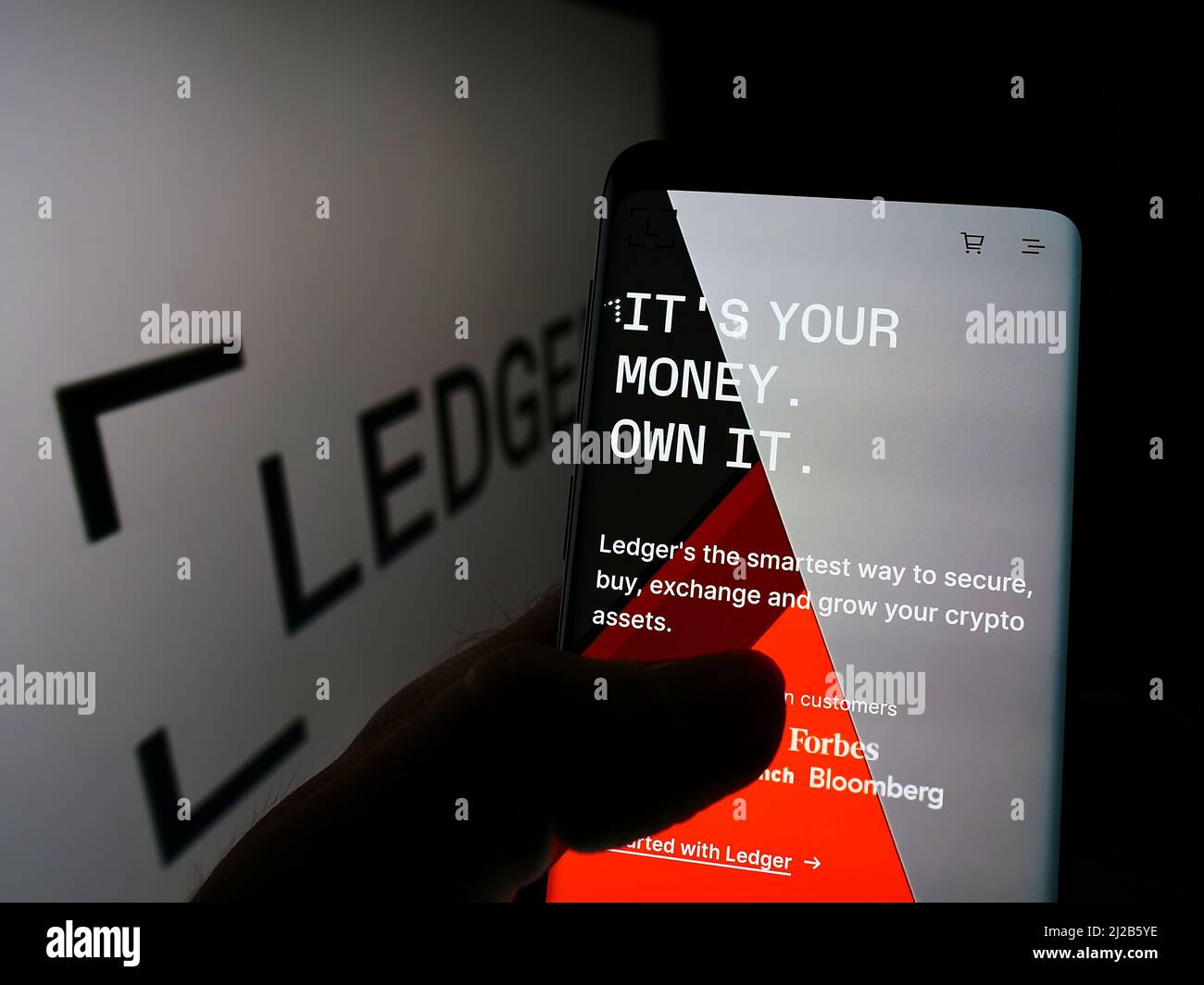 Personne tenant un téléphone portable avec le site Web de la société française d'actifs numériques Ledger SAS sur l'écran devant le logo. Concentrez-vous sur le centre de l'écran du téléphone. Banque D'Images