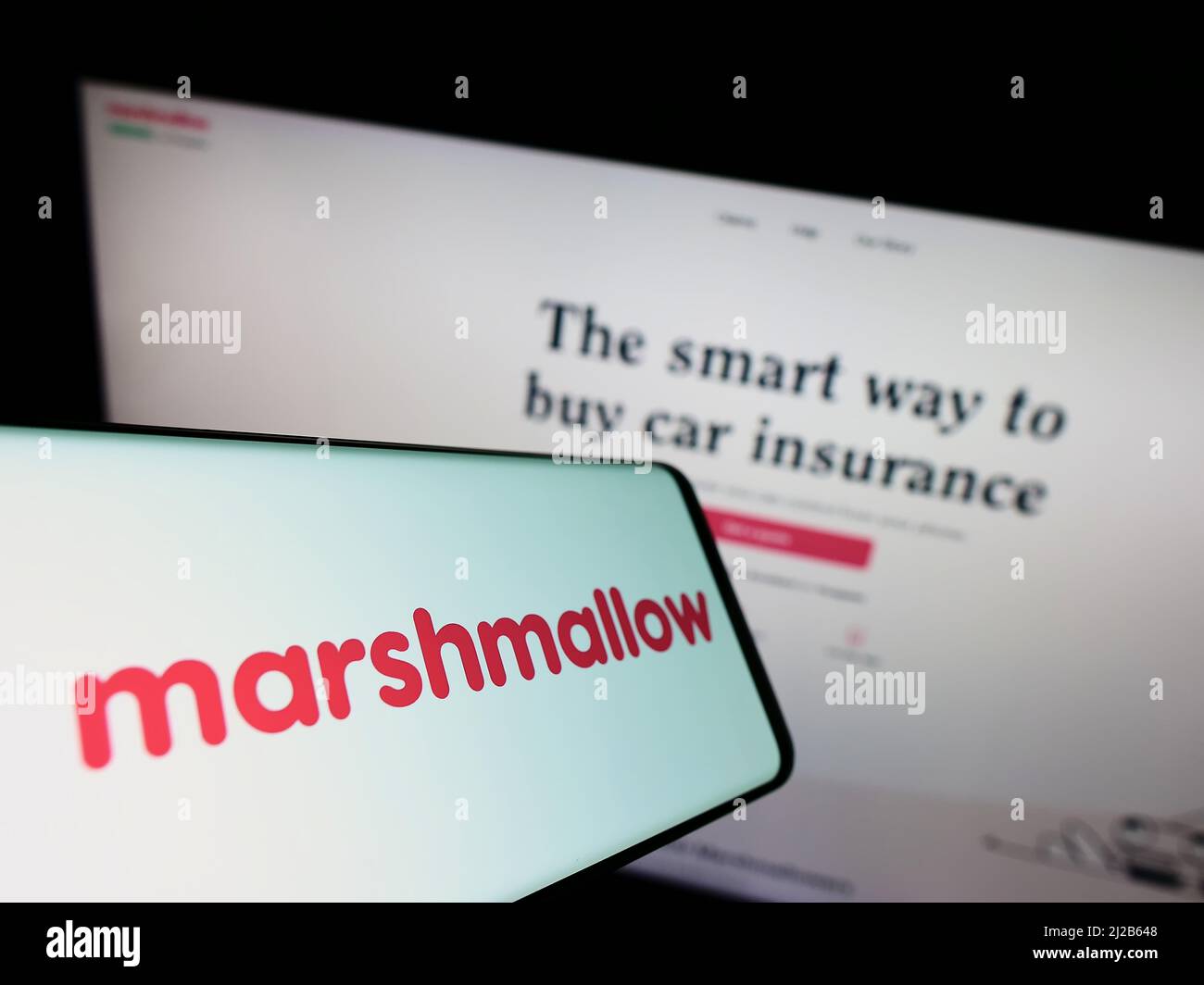 Smartphone avec logo de la société Marshmallow Financial Services Limited à l'écran devant le site Web. Effectuez la mise au point au centre-droit de l'écran du téléphone. Banque D'Images