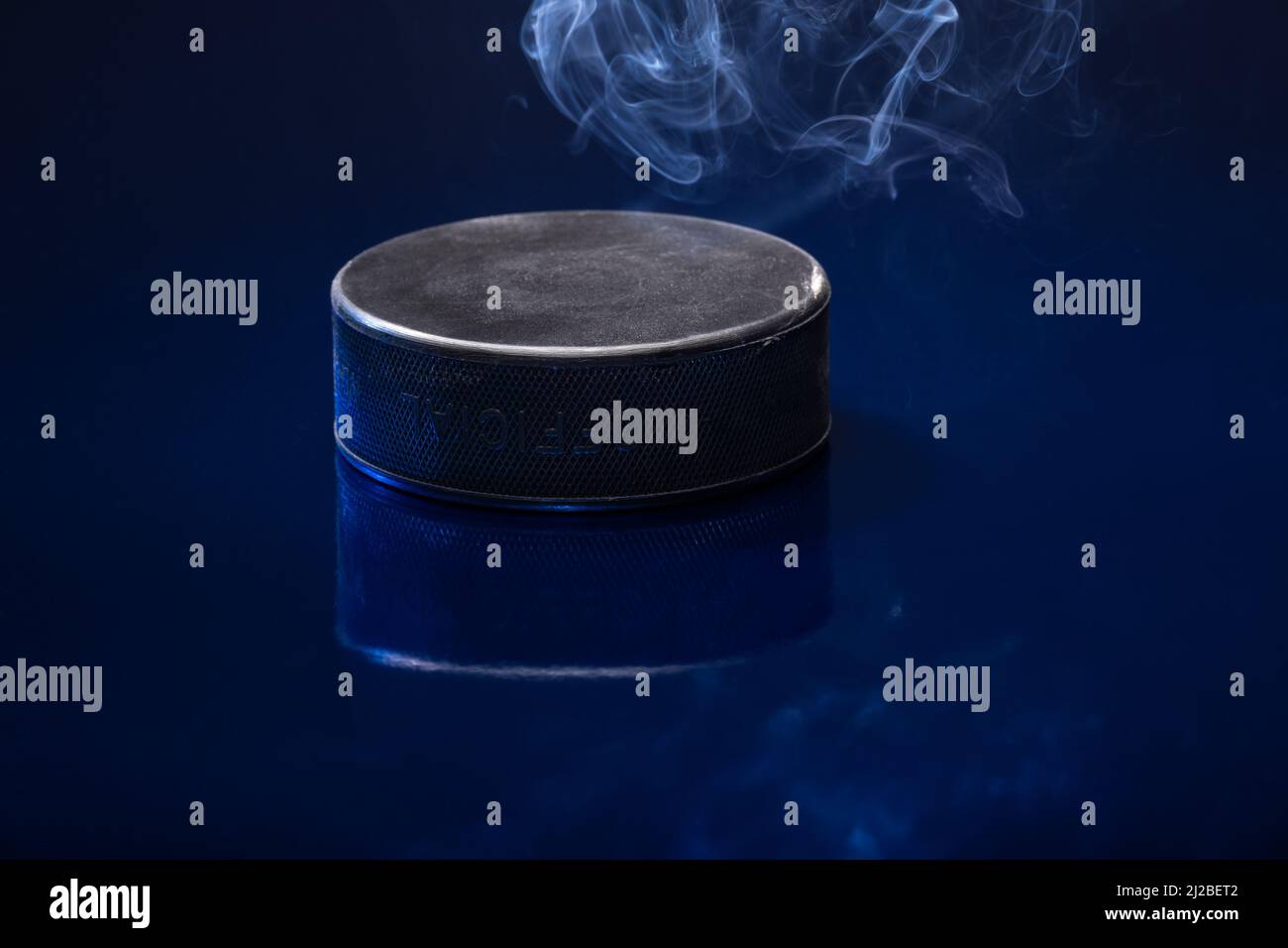 Helsinki / Finlande - 31 MARS 2022 : gros plan d'un palet de hockey sur glace noir sur fond bleu. Banque D'Images