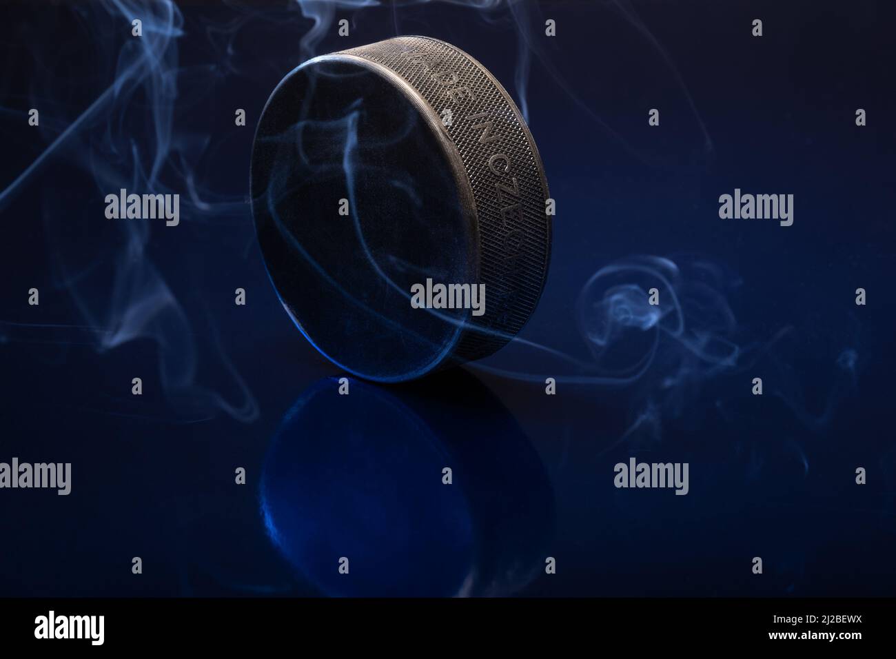 Helsinki / Finlande - 31 MARS 2022 : gros plan d'un palet de hockey sur glace noir sur fond bleu. Banque D'Images