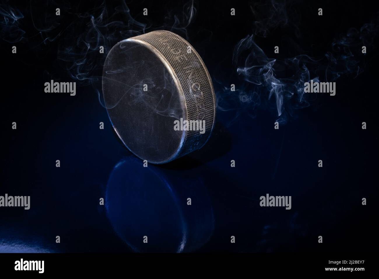 Helsinki / Finlande - 31 MARS 2022 : gros plan d'un palet de hockey sur glace noir sur fond bleu. Banque D'Images