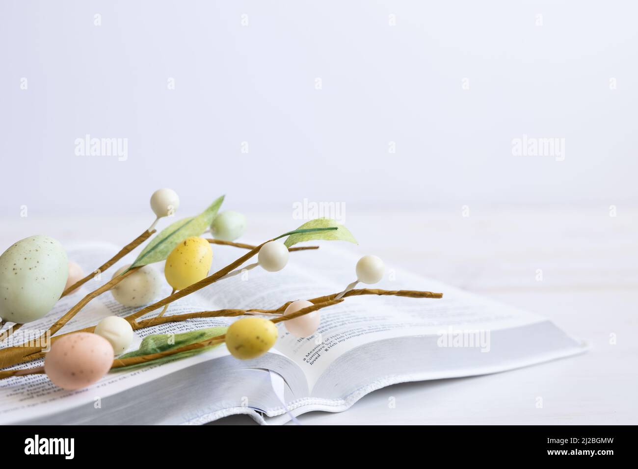 bible blanche avec tulipes blanches et décorations d'oeufs de pâques sur bois blanc avec espace de copie Banque D'Images