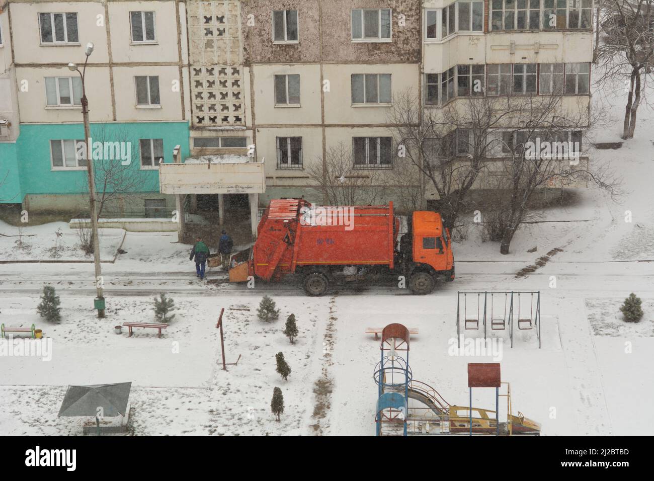 Employés de camions à ordures. Enlèvement des ordures dans le secteur résidentiel, les hommes de déchets chargeant les ordures ménagères dans un camion à ordures Banque D'Images