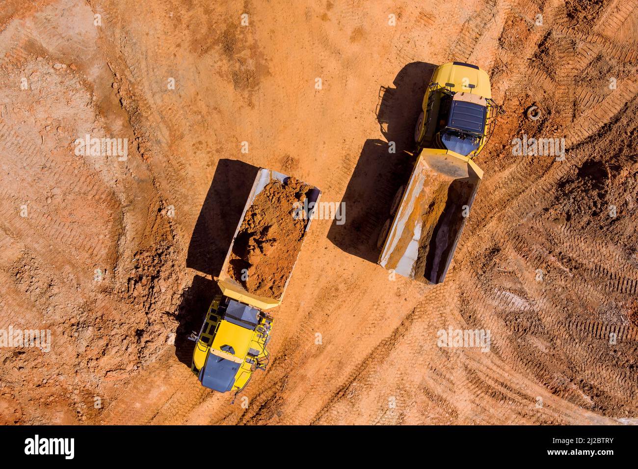 Vue aérienne du dessus de l'équipement lourd en mouvement de la terre sur le chantier de construction Banque D'Images