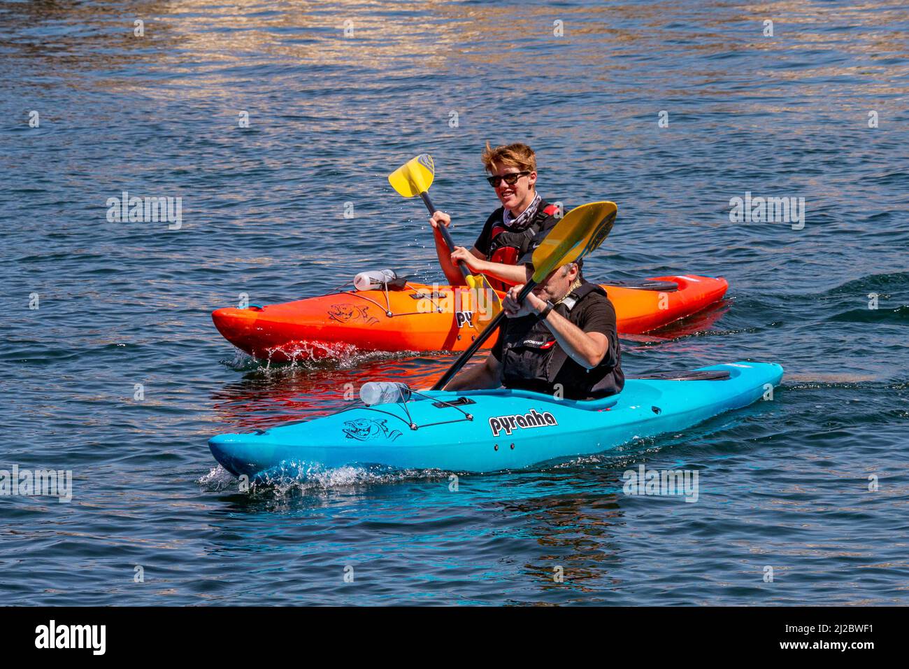 Deux kayakistes / canoéistes sur la rivière East Looe - Looe, Cornwall, Royaume-Uni. Banque D'Images