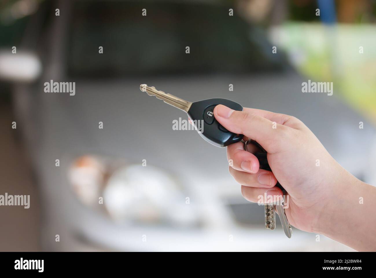 La main de la femme appuie sur la commande à distance des systèmes d'alarme de voiture Banque D'Images