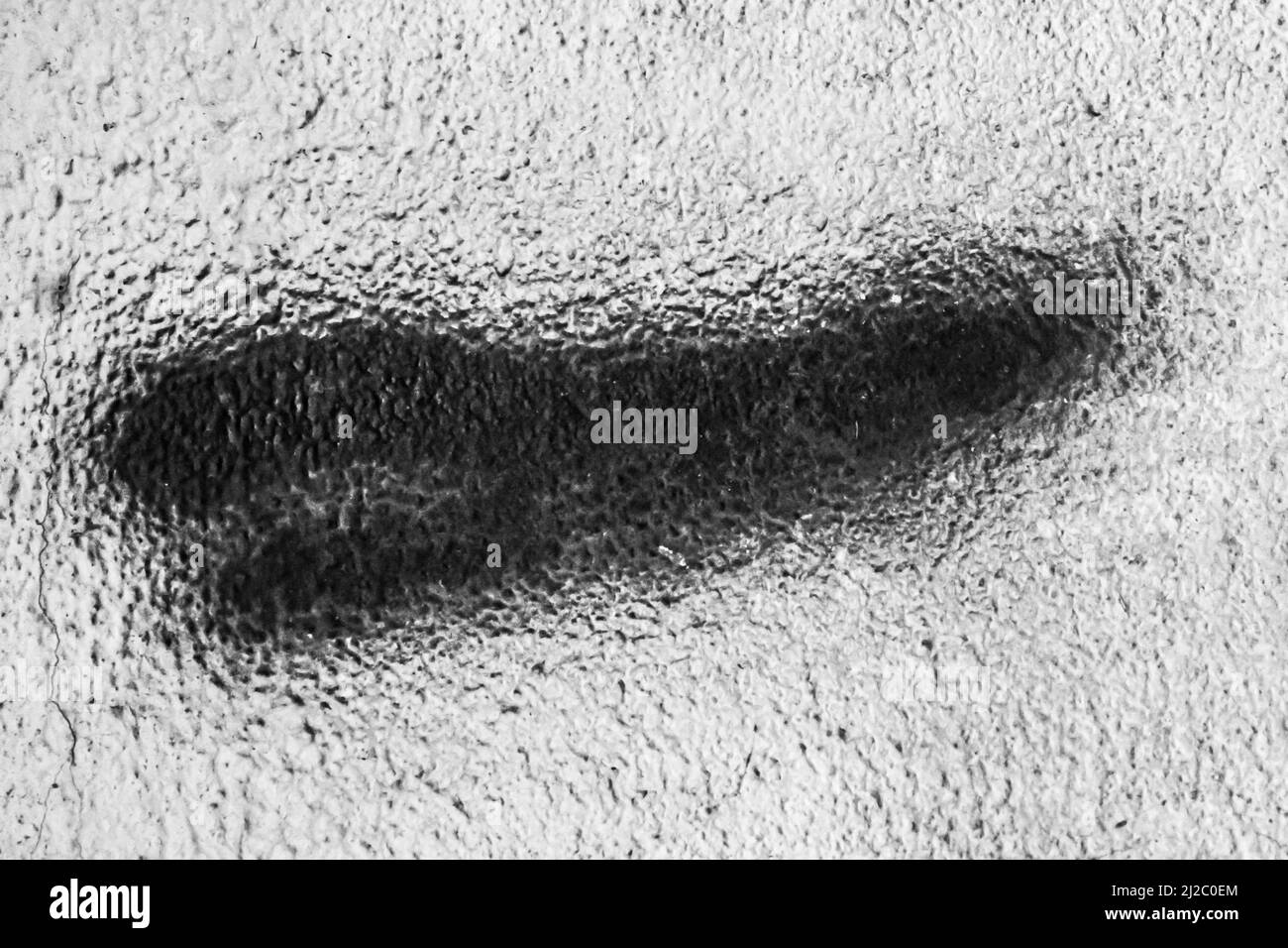 Trace d'un pinceau de peinture noire sur un vieux mur blanc en béton abstrait motif urbain design. Banque D'Images