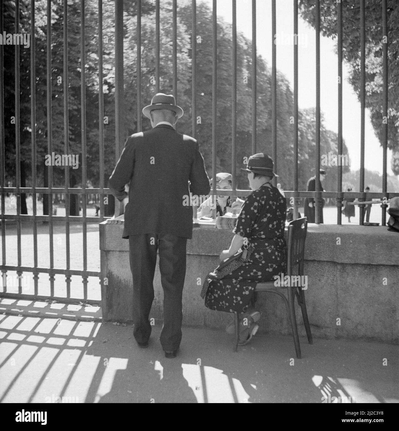 Vendeur de journaux avec client aux portes du jardin du Luxembourg ca: 1948 Banque D'Images