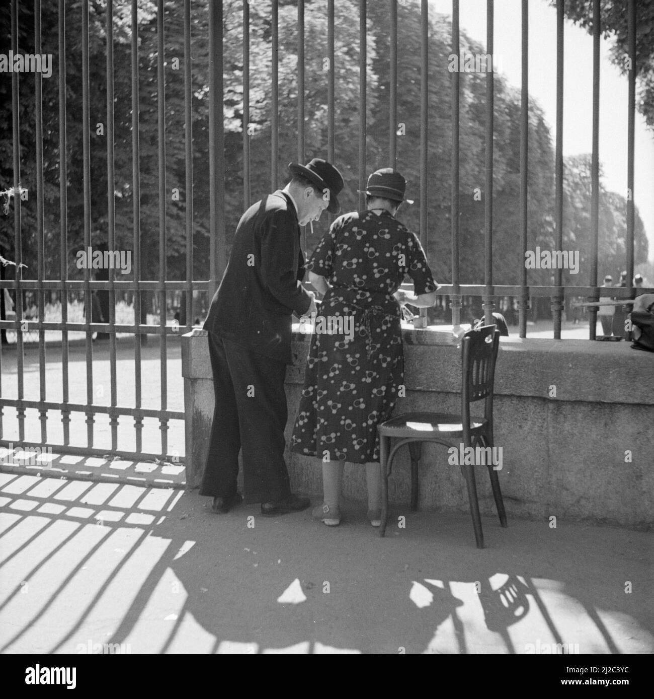 Vendeur de journaux avec client aux portes du jardin du Luxembourg ca: 1948 Banque D'Images