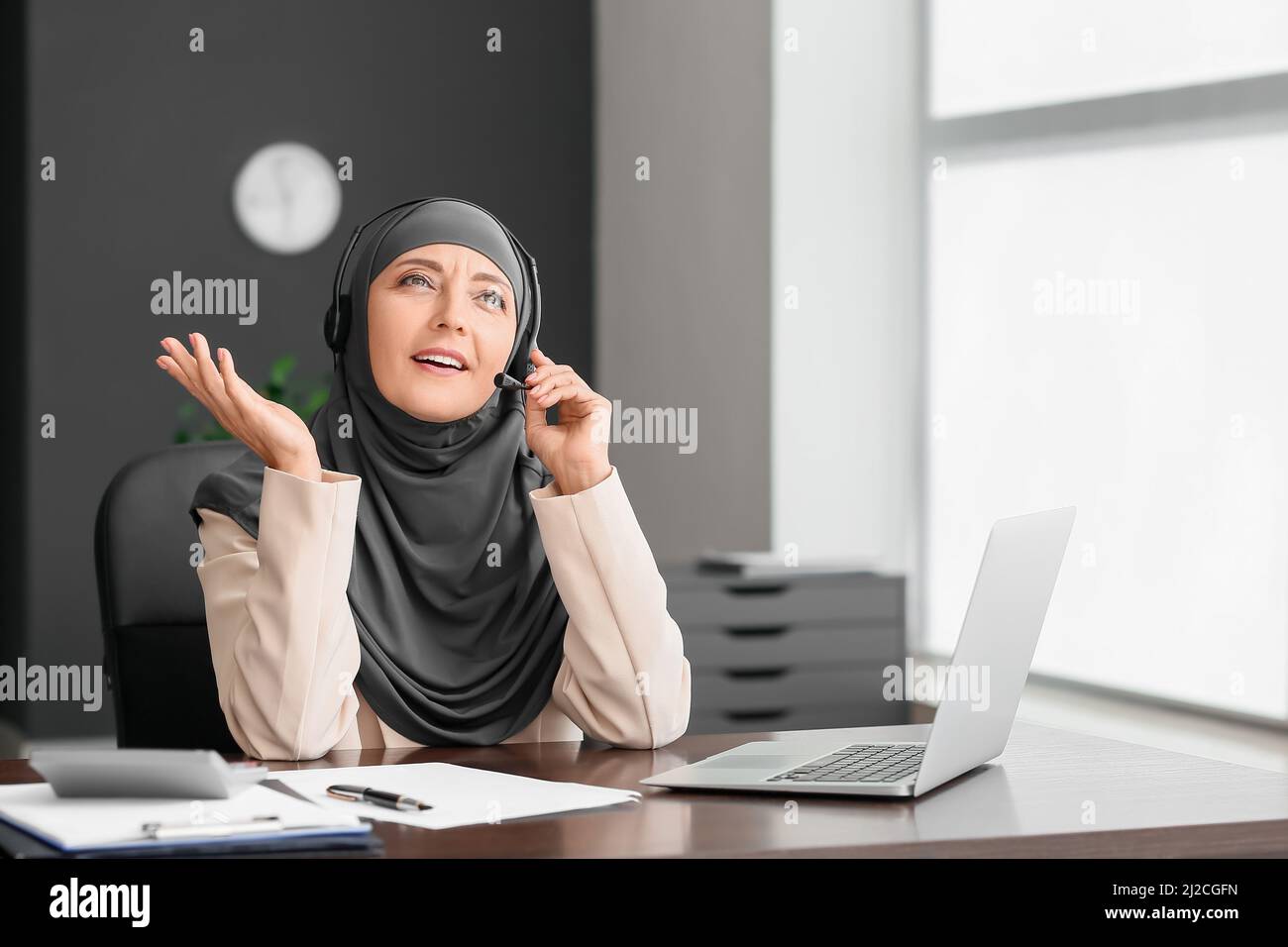 secrétaire musulman avec micro-casque travaillant au bureau Photo Stock -  Alamy