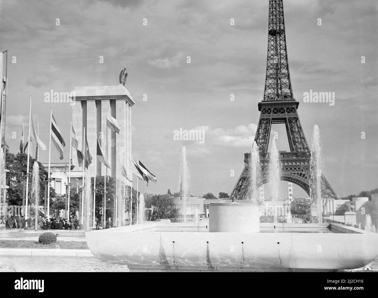 Le Pavillon allemand et la Tour Eiffel avec l'eau, les fontaines et les drapeaux ca: 1937 Banque D'Images