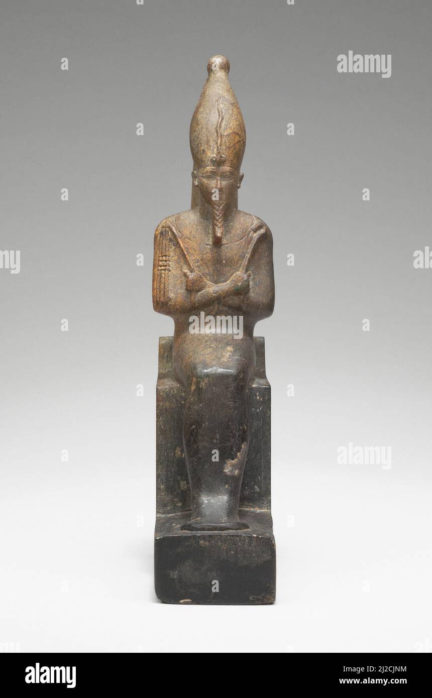 Cette figure finement sculptée du dieu Osiris dépeint la divinité momiforme assise sur un trône tenant un crook et un fléau, qui sont des symboles de sa capacité à gouverner et à fournir. Banque D'Images