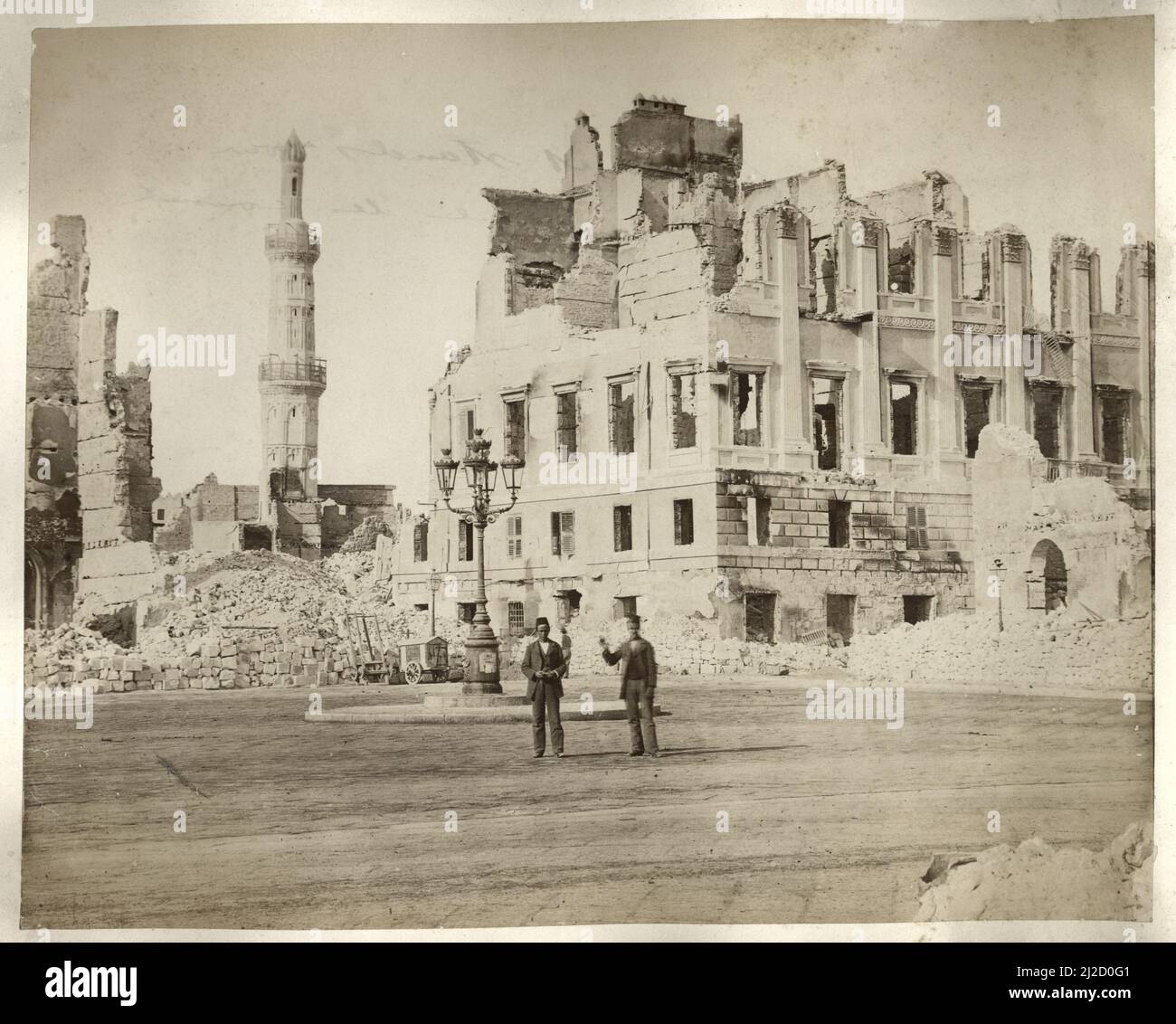 Deux hommes se tiennent près des maisons de Nubar Pasha et du Cheikh Ibrahim, en ruines après le bombardement d'Alexandrie par la flotte méditerranéenne britannique, Alexandrie, Egypte, 1882. Photographie de Luigi Fiorillo (1847 - 1898). Banque D'Images