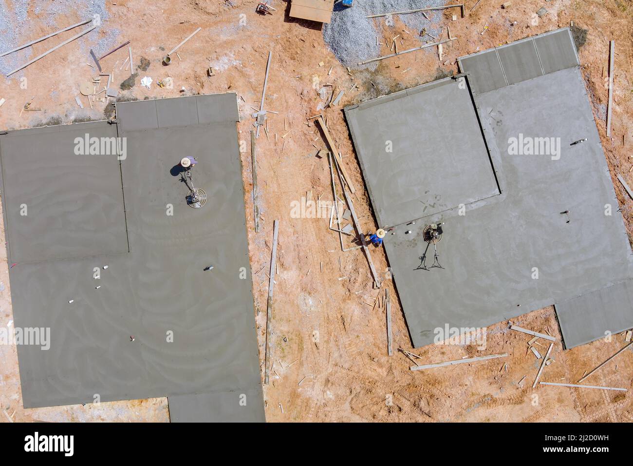 Vue aérienne du travailleur qui effectue le polissage des fondations de la table de ciment sur le chantier de construction du nouveau complexe de maisons Banque D'Images