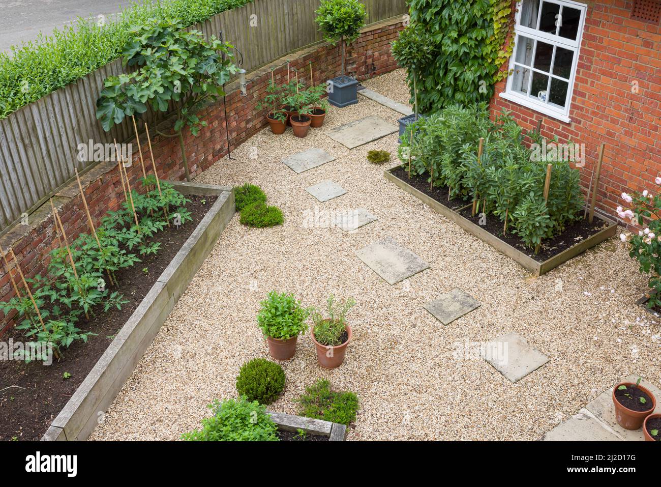 Jardin paysager Royaume-Uni. Aménagement paysager difficile avec gravier, pierres de pierre de York et lits surélevés en chêne Banque D'Images