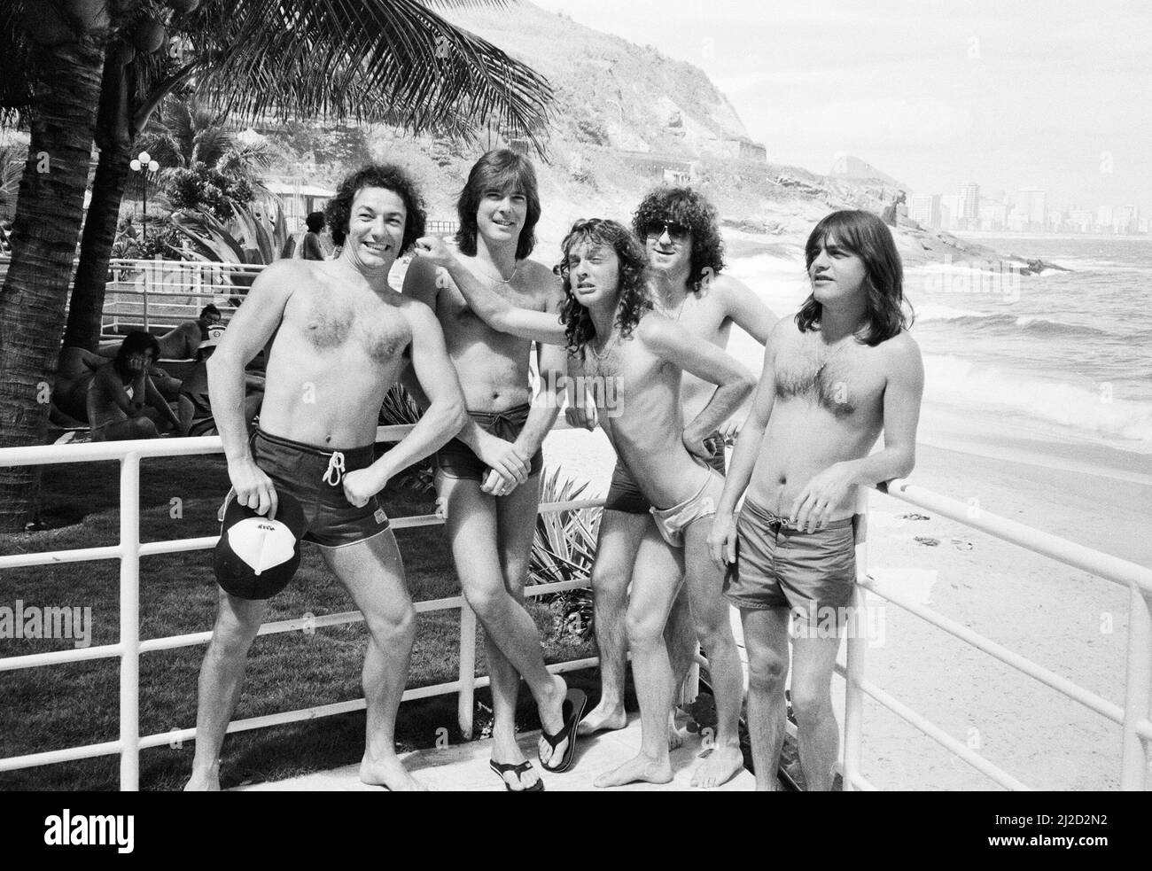 Le groupe de rock australien AC/DC prend le temps de se détendre à la plage d'Ipanema à Rio de Janeiro, au Brésil, lors de sa visite en Amérique du Sud. Ils sont dans la ville pour se produire au festival Rock in Rio au Rockedome, en terminant leur tournée mondiale « Flick of the Switch ». De gauche à droite : chanteur Brian Johnson, Cliff Williams, Simon Wright, Angus Young, Malcolm Young. Janvier 1985. Banque D'Images