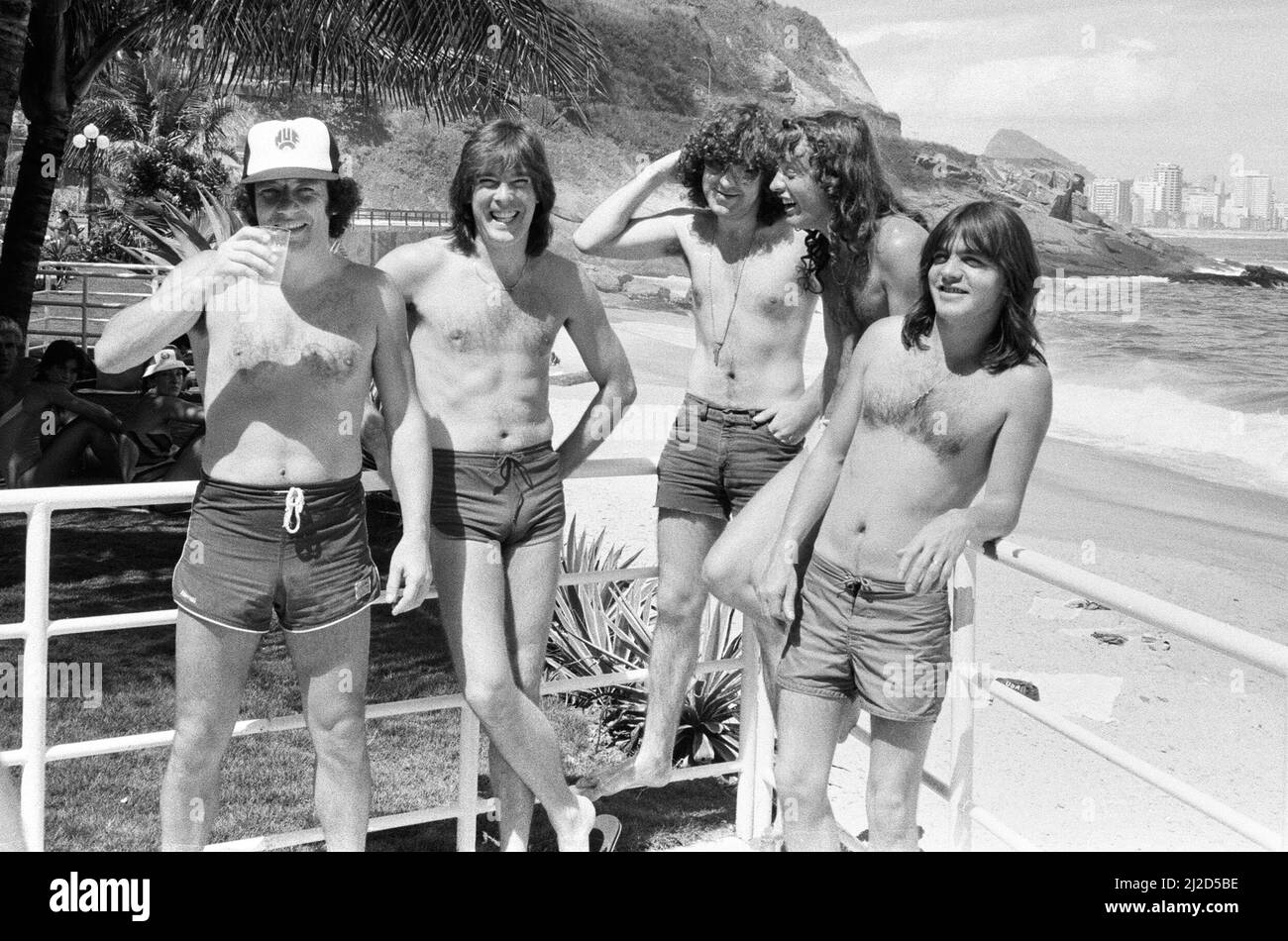 Le groupe de rock australien AC/DC prend le temps de se détendre à la plage d'Ipanema à Rio de Janeiro, au Brésil, pendant la visite en Amérique du Sud. Ils sont dans la ville pour se produire au festival Rock in Rio au Rockedome, en terminant leur tournée mondiale « Flick of the Switch ». De gauche à droite : chanteur Brian Johnson, Cliff Williams, Simon Wright, Angus Young, Malcolm Young. Janvier 1985. Banque D'Images
