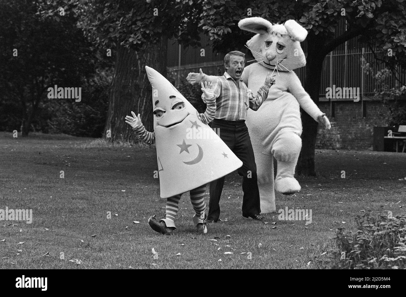 Le magicien Paul Daniels avec ses costars dans le programme de la BBC pour enfants 'Wizbit'. Il est photographié avec Wizbit, une étrange créature magique qui ressemble à un chapeau de sorcier jaune. Et son ami Wooly, un lapin blanc tricoté de huit pieds. 4th septembre 1985. Banque D'Images