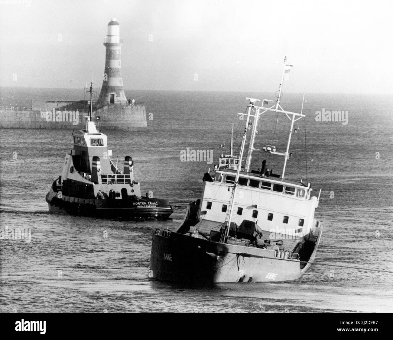 Naufrages du Nord-est - Une opération massive de sauvetage air-mer a été montée au large de la côte de la mer du Nord pour sauver un navire hollandais en naufrage et son équipage de cinq. Les équipes d'urgence se sont mises à côté pendant que le cargo en naufrage Anne a été remorqué dans Sunderland et avec la mer qui s'est traînante à quelques centimètres de son rail portuaire, elle l'a fait à la petite heure. Le travailleur au quai a immédiatement commencé une opération pour maintenir le navire à flot. 27th novembre 1985. Banque D'Images