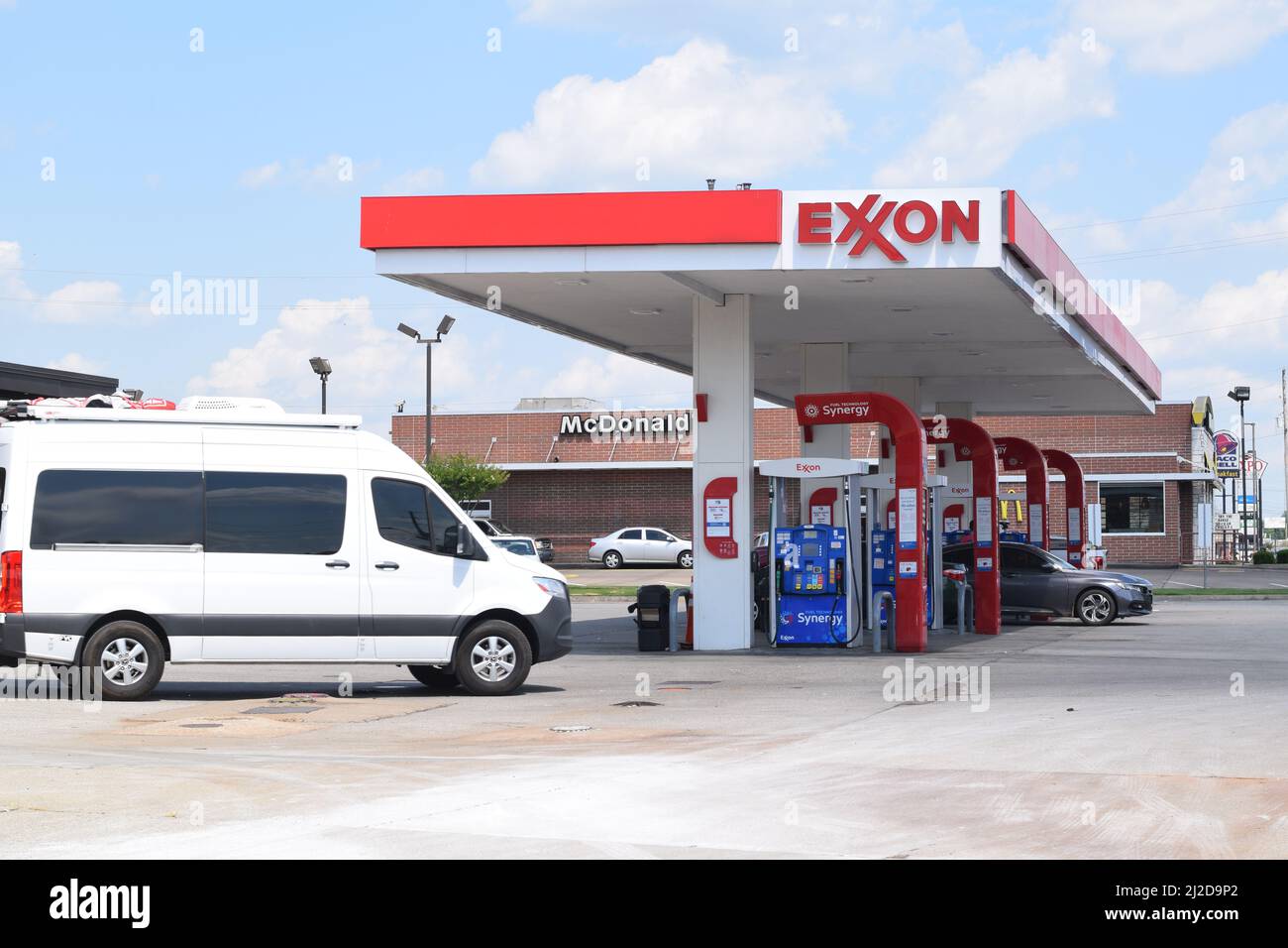 Une camionnette blanche s'approche des pompes à gaz d'une station-service Exxon Banque D'Images