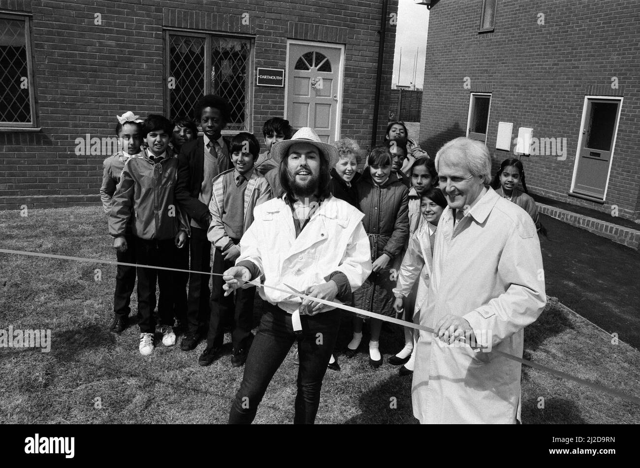 Dave Hill, star du slade, a essayé de ne pas « faire tomber la maison » lorsqu'il a fait une visite de retour après 20 ans dans son vieux lieu de travail. Il ouvrait deux maisons de spectacle pour un développement de 67 bâtiments à Heathcroft, Wolverhampton pour Tarmac Houses (Midlands). Il était un acheteur stagiaire pour Tarmac à l'âge de 18 ans, avant de tirer à la stardom. Des enfants de l'école junior de farandole étaient sur place pour voir Dave couper le ruban - ils ont suivi le développement et l'histoire du site comme un projet scolaire. 12th juin 1985. Banque D'Images