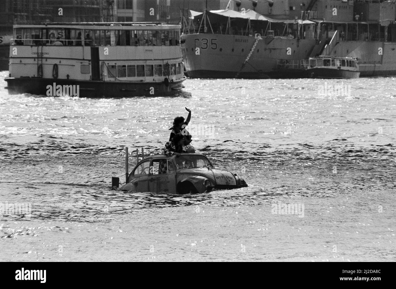 Peter Duncan, présentateur de télévision, dans une voiture VW Beetle dans la Tamise, près de Tower Bridge. 10th juillet 1986. Banque D'Images