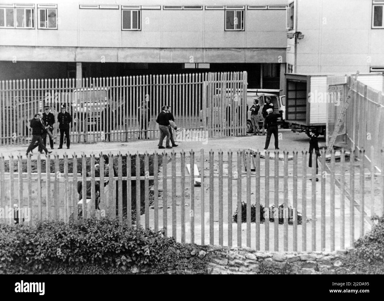 Les responsables de la sécurité transportent un démonstrateur pour louer des fourgonnettes afin des retirer du site du bunker nucléaire de Carmarthen. Octobre 1985. Banque D'Images