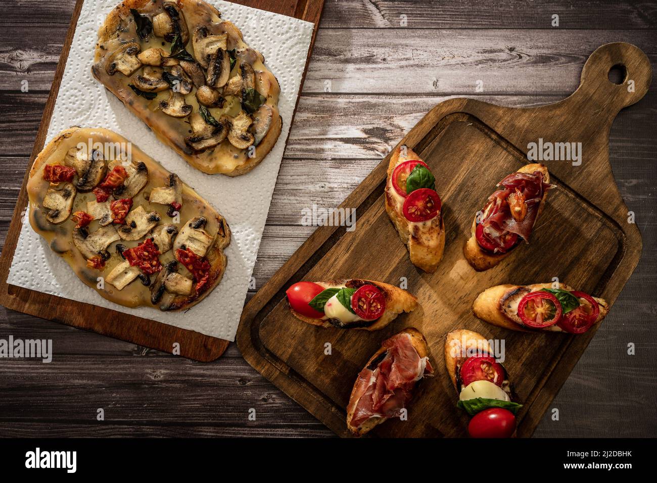 Arrangement d'une sélection de différents tapas ou bruschettas sur un panneau en bois. Concept alimentaire méditerranéen. Banque D'Images